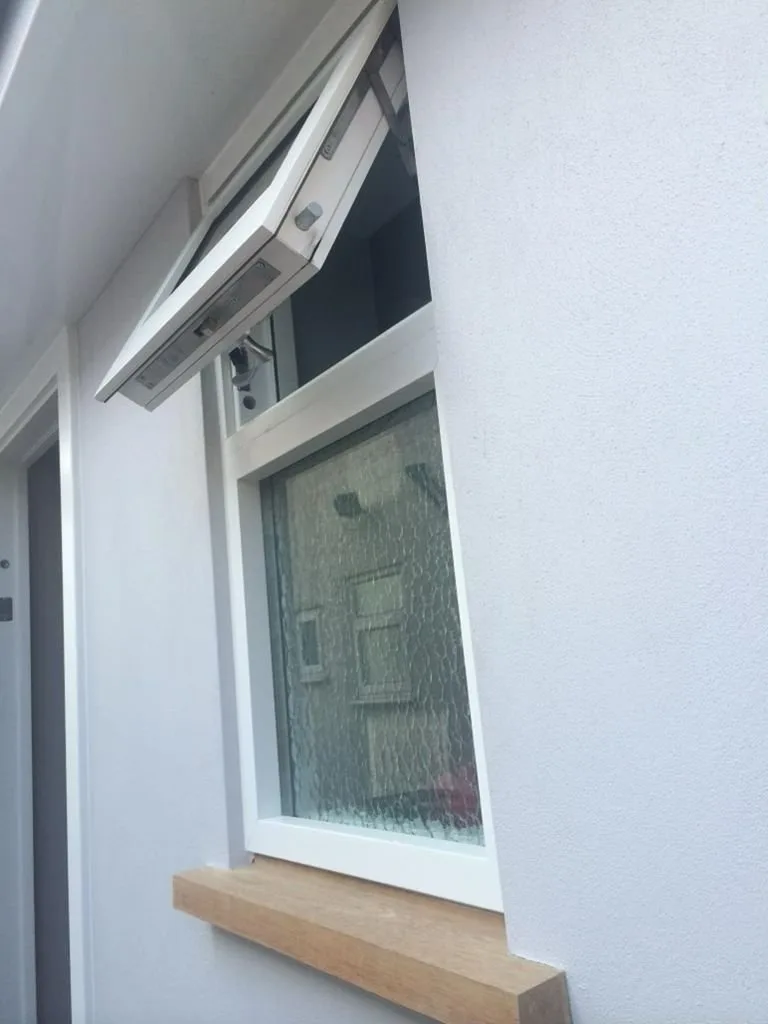 Top-hung security window with the top sash hinged outward providing controlled ventilation